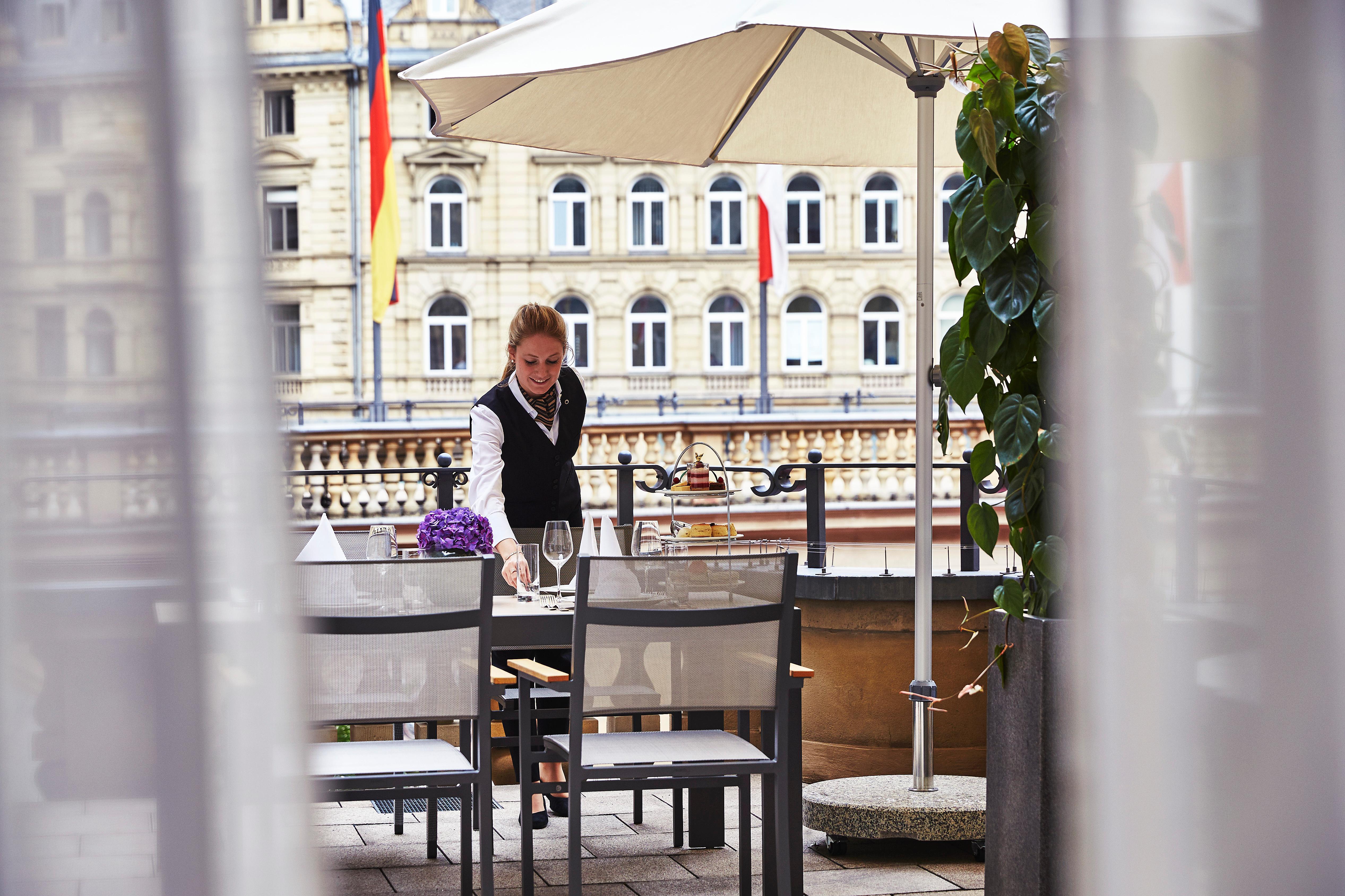 美因河畔法兰克福 施泰根博阁法兰克福饭店酒店 外观 照片 A waitress clearing a table at a restaurant